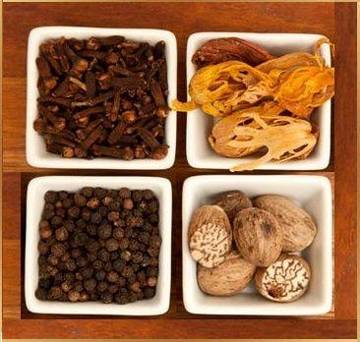 Cloves, mace, black pepper and nutmeg in a wooden tray